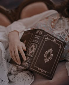 a woman is laying down holding a book