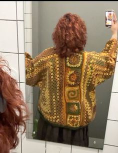 a woman taking a selfie in front of a bathroom mirror with her cell phone