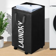 a laundry hamper next to a washing machine and a potted plant on the floor