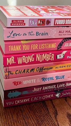 a stack of children's books sitting on top of a wooden table in front of a window