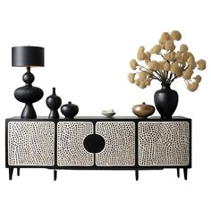 a black and white sideboard with vases on it