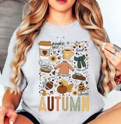 Autumn Doodles Tee (001) | Cozy Fall T-Shirts | Unique Gifts for Family Friends   Embrace the coziness of fall with our cute, groovy, and retro t-shirts. Welcome the crisp air and vibrant hues of fall with our exclusive Autumn tees! Designed to capture the season's spirit perfectly, these tees are a must-have for your autumn wardrobe. Made from premium, breathable cotton, our t-shirts ensure maximum comfort for those cool fall days and cozy bonfire nights.   Key Features: High-Quality Material: Cozy Graphic Print Tops For Fall, Trendy Cartoon Print Tops For Fall, Cozy Short Sleeve Tops For Fall, Casual Printed T-shirt For Fall, Relaxed Fit Cartoon Print Top For Fall, Fun Fall Top With Letter Print, Fun Letter Print Tops For Fall, Fun Letter Print Top For Fall, Casual Printed Fall T-shirt