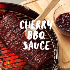 the ribs are being grilled on the grill with cherry bbq sauce next to it