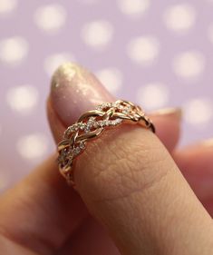 a close up of a person's hand with a gold ring on their finger