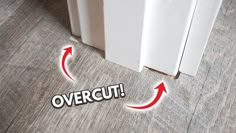 an overcut sticker is on the floor next to a door with red arrows