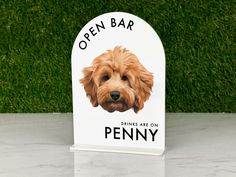 an open bar sign with a dog's face on it and the name penny