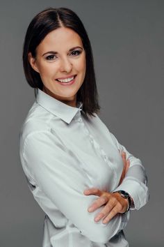 a woman with her arms crossed posing for a photo