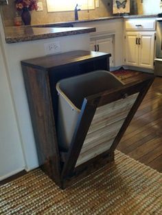 a trash can sitting in the middle of a kitchen