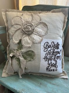 a pillow with a flower on it sitting on a chair