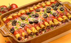 a casserole dish filled with taco meat, cheese and black olives