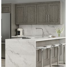 a kitchen with marble counter tops and stools in front of the refrigerator freezer