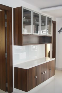 an empty kitchen with wooden cabinets and white counter tops