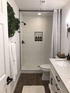 a bathroom with white walls and wood floors