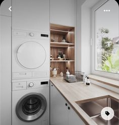 a washer sitting next to a window in a kitchen near a sink and counter