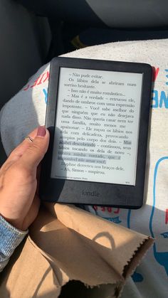 a person is holding an electronic device in their hand while sitting on the back seat