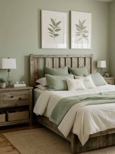 a bedroom with green walls and white bedding, two framed pictures on the wall