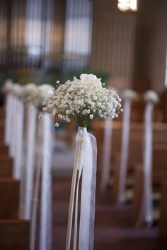 the flowers are in vases on the pews at the wedding ceremony, ready to be carried down the aisle