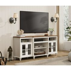 a large flat screen tv mounted to the side of a white entertainment center in a living room