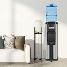 a water dispenser sitting next to a couch in a room with white walls