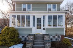 a house with steps leading up to the front door and two windows on each side