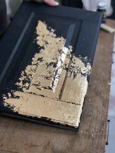 an old door is being painted black and gold with some paint on it's side