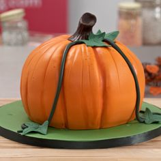 a pumpkin shaped cake sitting on top of a wooden table