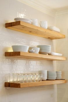 two wooden shelves filled with dishes and glasses