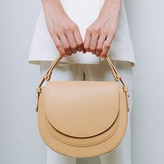 Almond Saddle Bag Chic Saddle Bag With Detachable Handle For Everyday, Handheld Phone Bag With Detachable Strap For On-the-go, Handheld Phone Bag With Detachable Strap, Trendy Saddle Bag With Gold-tone Hardware For Everyday, Beige Handheld Phone Bag For Everyday, Chic Beige Phone Bag For Everyday Use, Chic Beige Everyday Phone Bag, Everyday Shoulder Bag With Adjustable Round Handle, Leather Handheld Phone Bag With Adjustable Strap