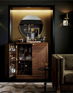 a wine cabinet with bottles and glasses in front of a mirror that is on the wall