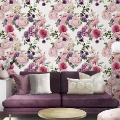 a living room with floral wallpaper and purple couch