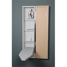 an ironing board is in the door of a cabinet