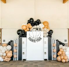 balloons and streamers decorate the entrance to a sports themed birthday party with basketball theme