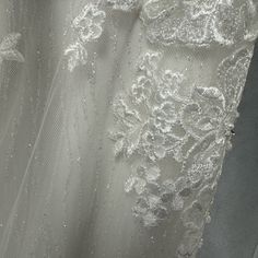 wedding dress with white lace and beading on the bottom, close up view from behind