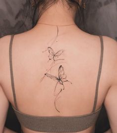 a woman with a butterfly tattoo on her back