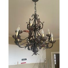 a chandelier hanging from the ceiling in a room with stairs leading up to it