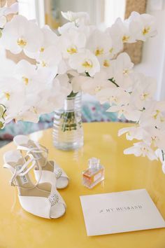 a pair of white shoes sitting on top of a yellow table