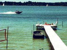 a boat traveling across a body of water next to a pier