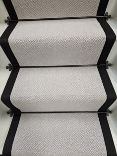 an image of some stairs with black and white carpet