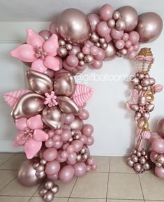 balloons are arranged in the shape of flowers and butterflies for a balloon arch with pink accents