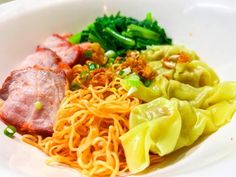 a white bowl filled with noodles, meat and veggies