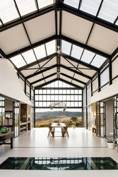 an indoor swimming pool in the middle of a room with large windows and glass walls