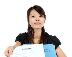 a woman holding up a resume in front of her face