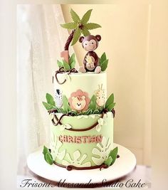 a three tiered cake decorated with monkeys on top and jungle animals on the bottom