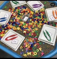 there are many different letters and scissors on the table with plastic trays in front of them