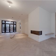 an empty room with white walls and wood floors