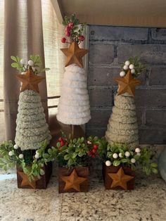 three small christmas trees sitting on top of a counter