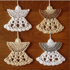 four crocheted ornaments are hanging on a table together, one is white and the other is gold