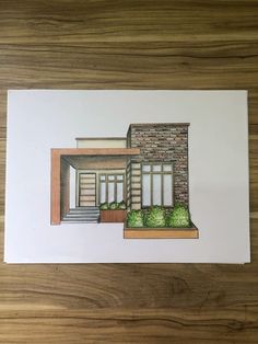 a drawing of a house on top of a wooden table