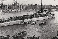 an old black and white photo of boats in the water with people standing on them