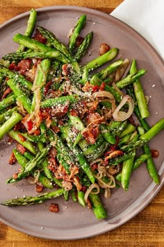 asparagus with bacon, onions and parmesan cheese on a plate